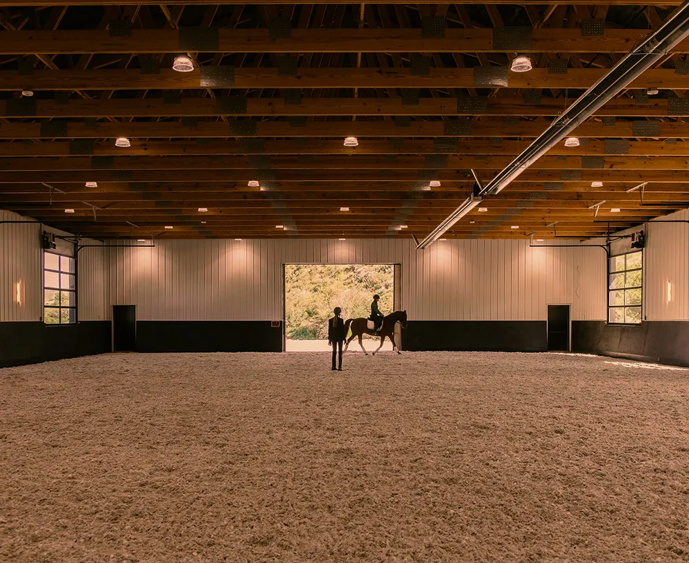 Indoor riding arena designed for year-round horseback training and instruction.
